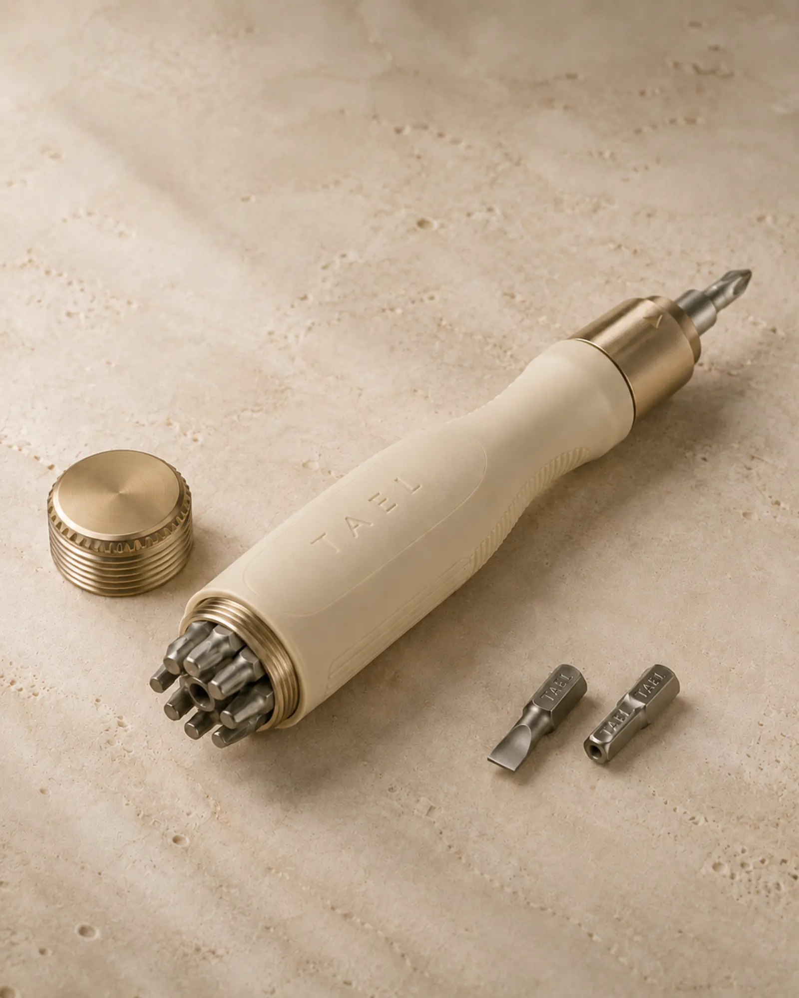 The Tael screwdriver with brass end cap removed, revealing eight precision bits stored inside the handle.